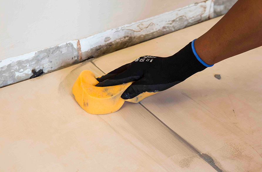 Clean the grout off the tile face before it hardens completely